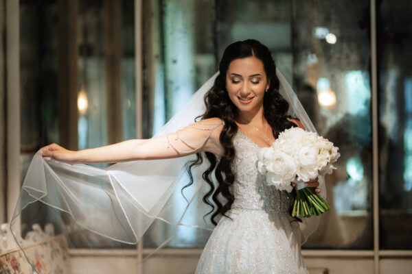 portrait of a bride in a white dress in a bright cafe with mirrors